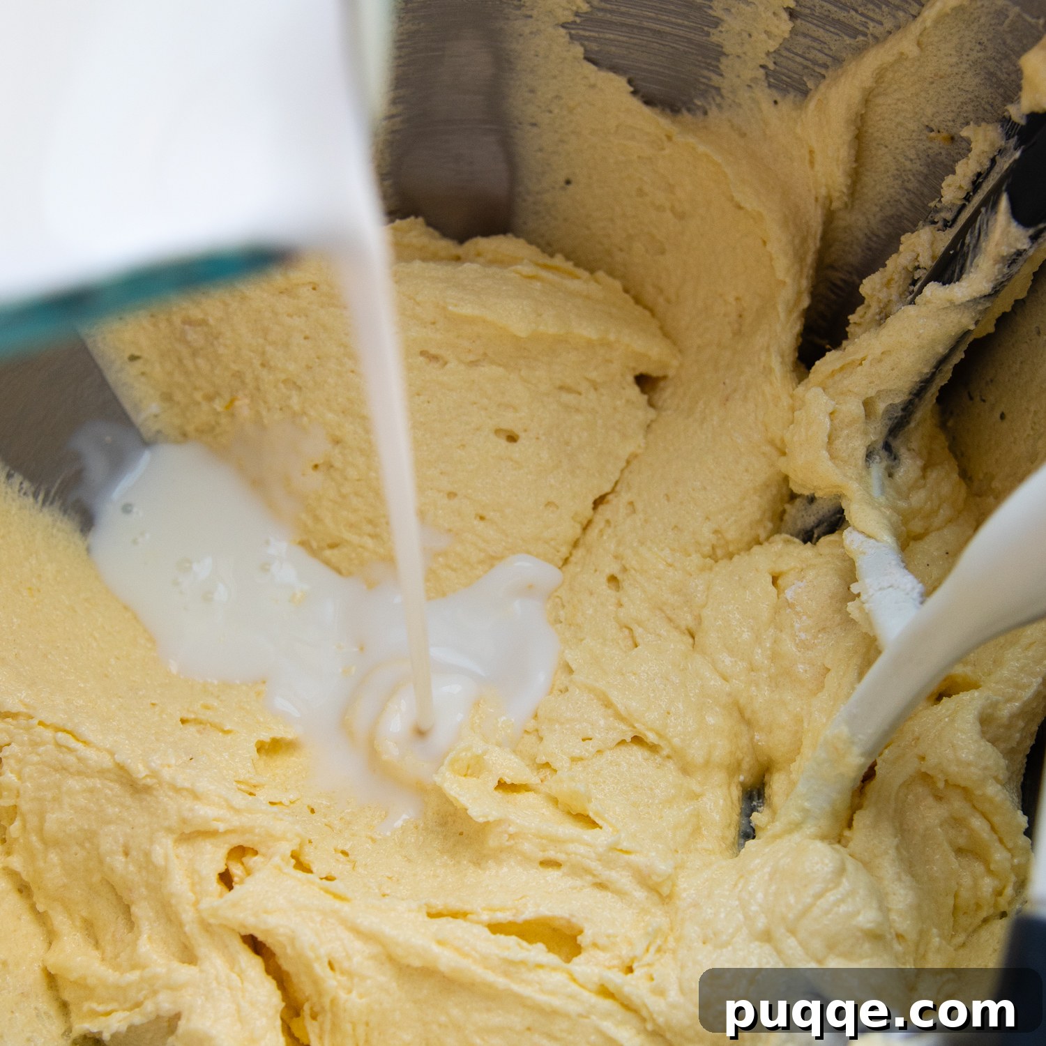 Decadently Moist Gluten-Free Coconut Lemon Curd Velvet Cake 6 A stream of rich coconut milk being carefully poured into the cake batter, midway through the alternating wet and dry ingredient additions.