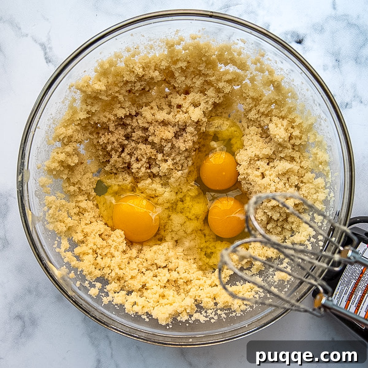 cake batter with eggs being beat in.