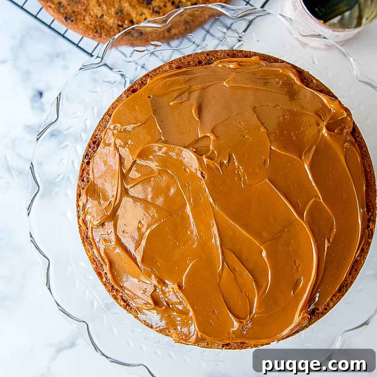 dulce de leche being spread on a cake layer.