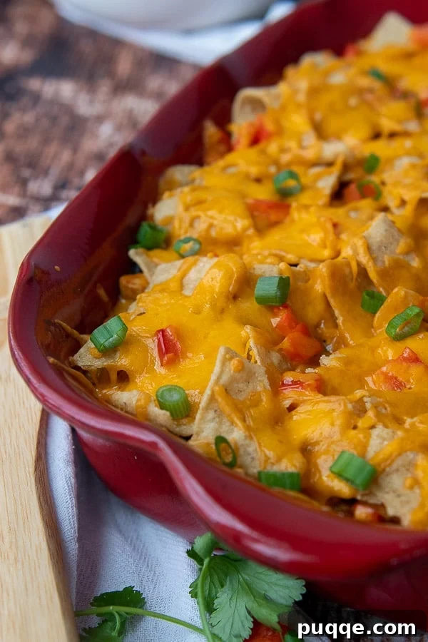 Close-up of a bubbling Mexican chicken casserole with melted cheese and fresh cilantro.