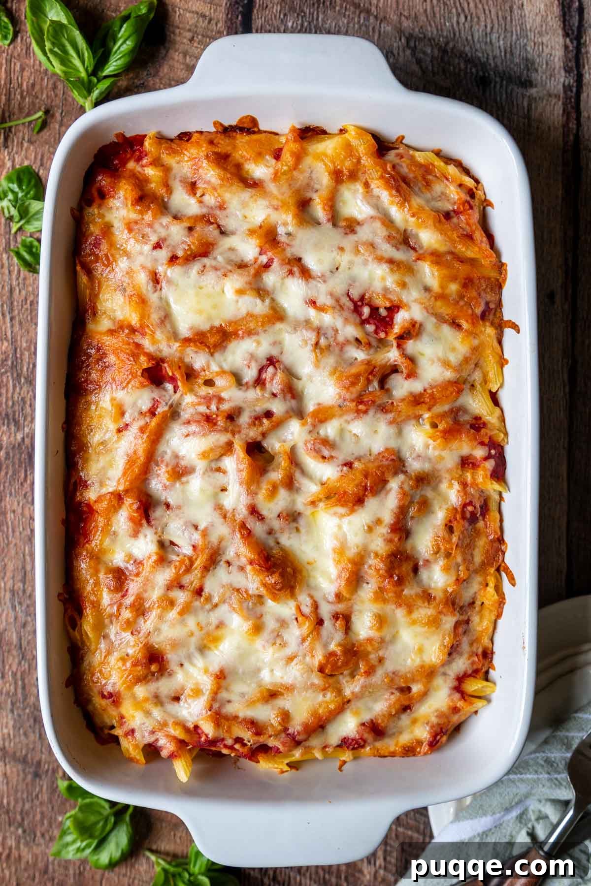 Overhead shot of a bubbling baked ziti in a white baking dish, ready to serve.