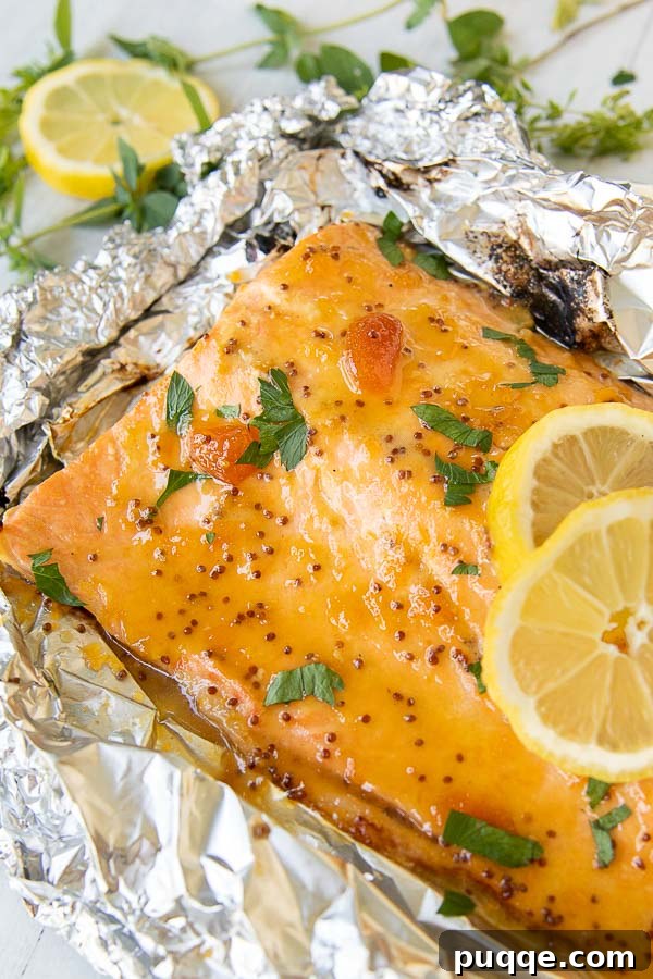 Perfectly grilled salmon nestled in foil, topped with fresh lemon slices.