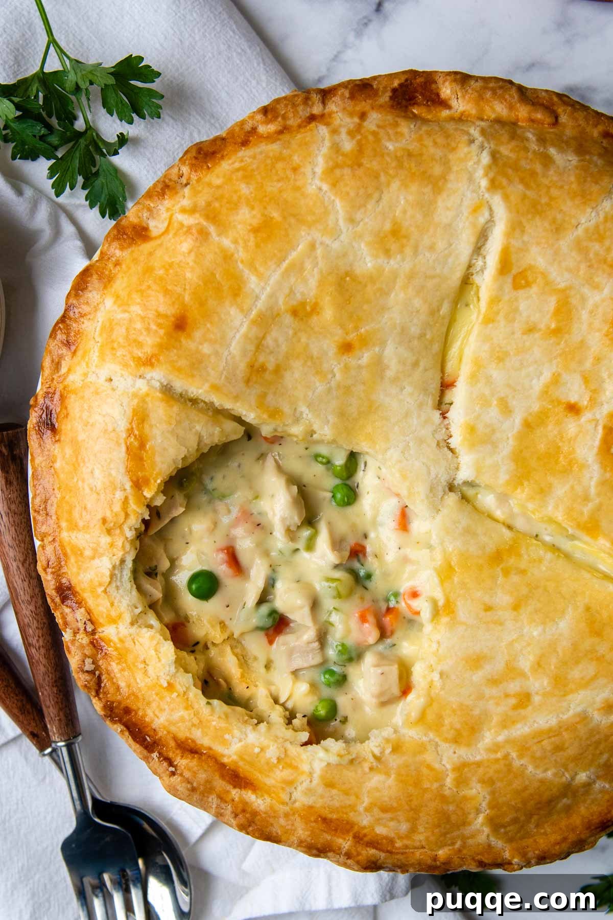 Overhead shot of a golden gluten-free pot pie with a portion removed, revealing a creamy filling.