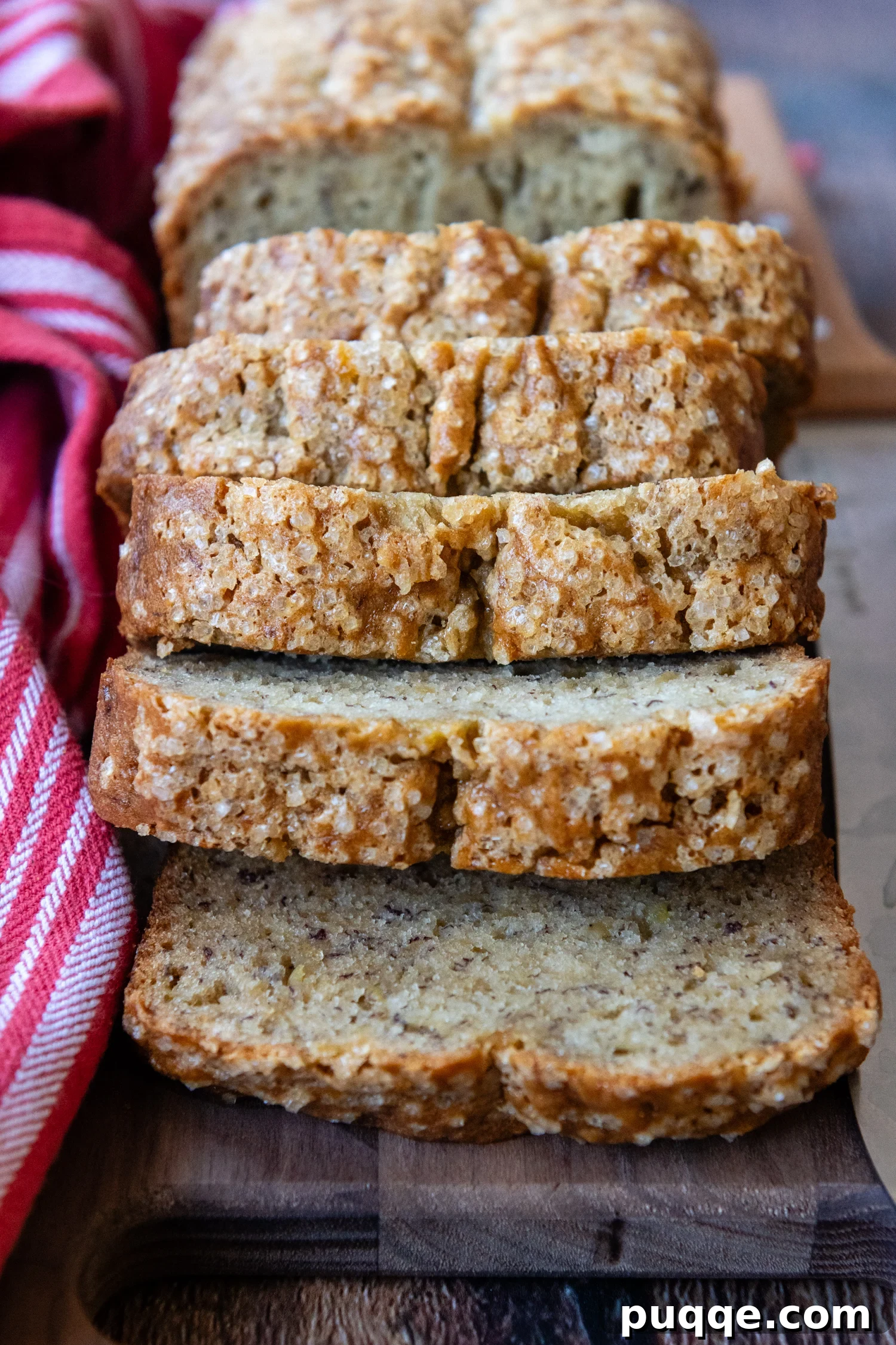 Delicious slices of moist gluten-free banana bread artfully arranged on a wooden cutting board.