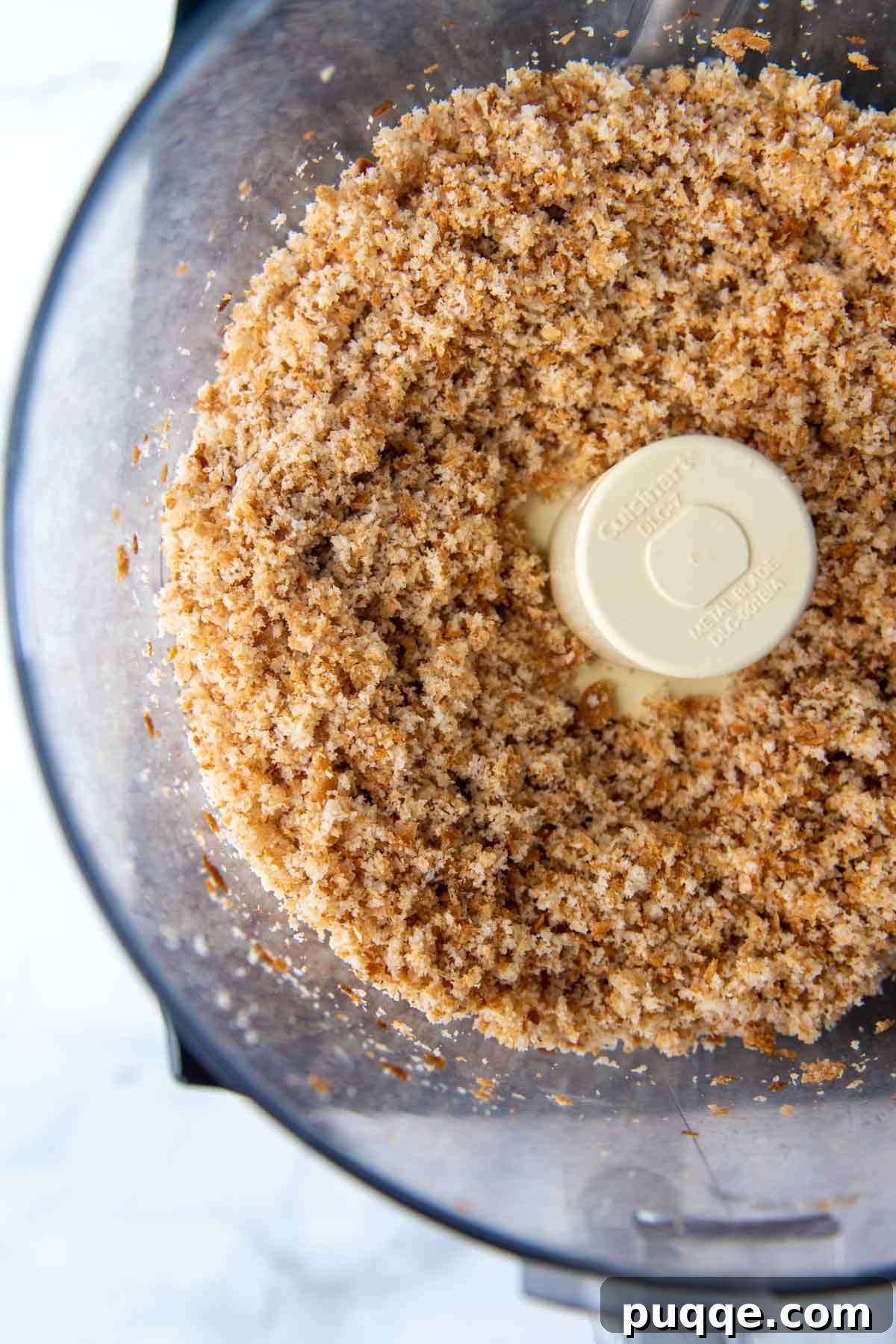 Overhead shot of gluten-free breadcrumbs in a food processor, ready for seasoning or baking.
