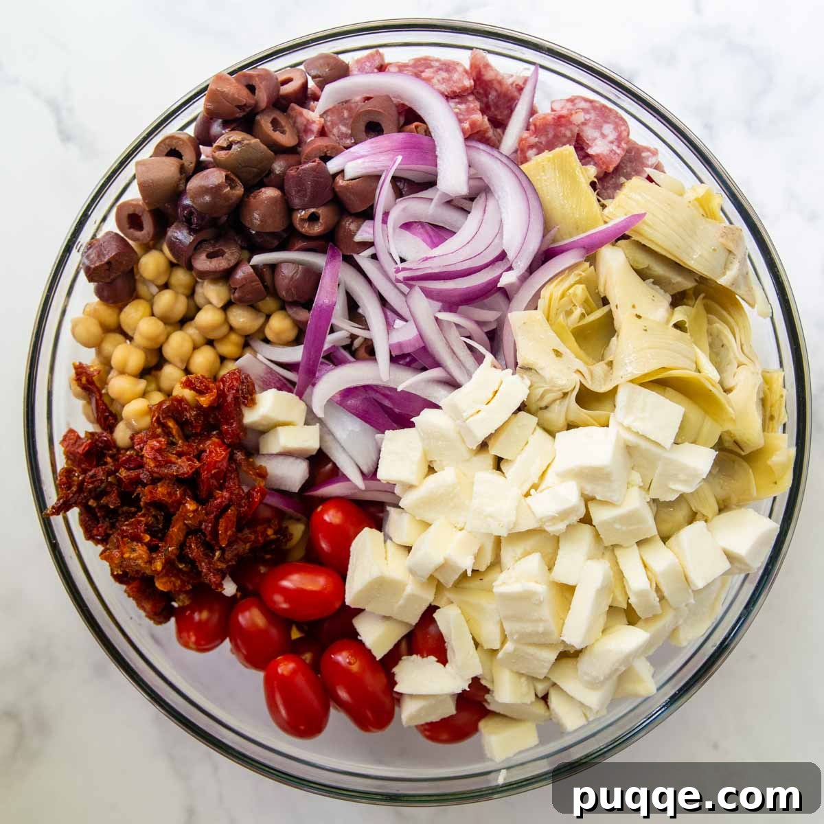 Vibrant Gluten-Free Pasta Salad with Sun-Dried Tomato Dressing 3 various ingredients, including pasta, vegetables, and meats, ready to be mixed for the salad.