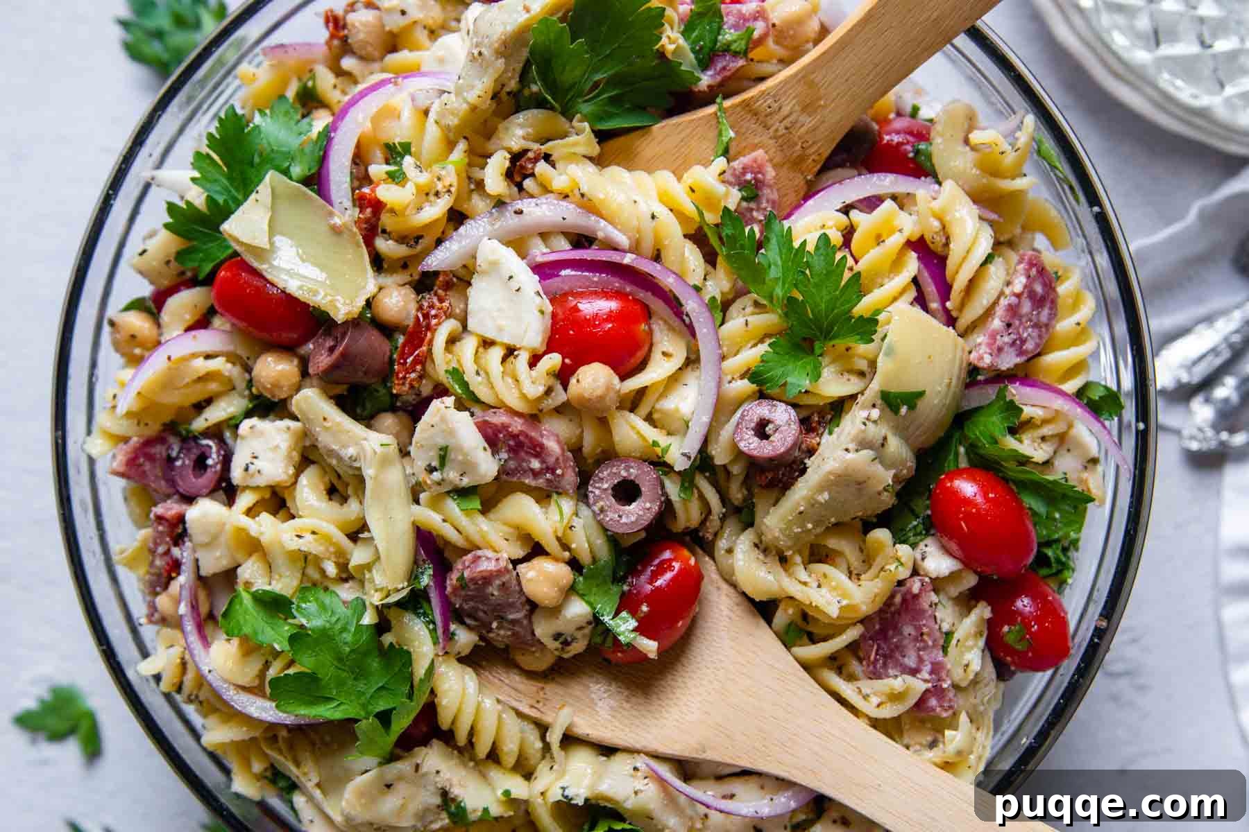 Vibrant Gluten-Free Pasta Salad with Sun-Dried Tomato Dressing 5 overhead shot of gluten-free pasta salad with wooden spoons in bowl, ready to serve.