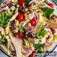 overhead shot of pasta salad in a glass bowl, ready to serve.