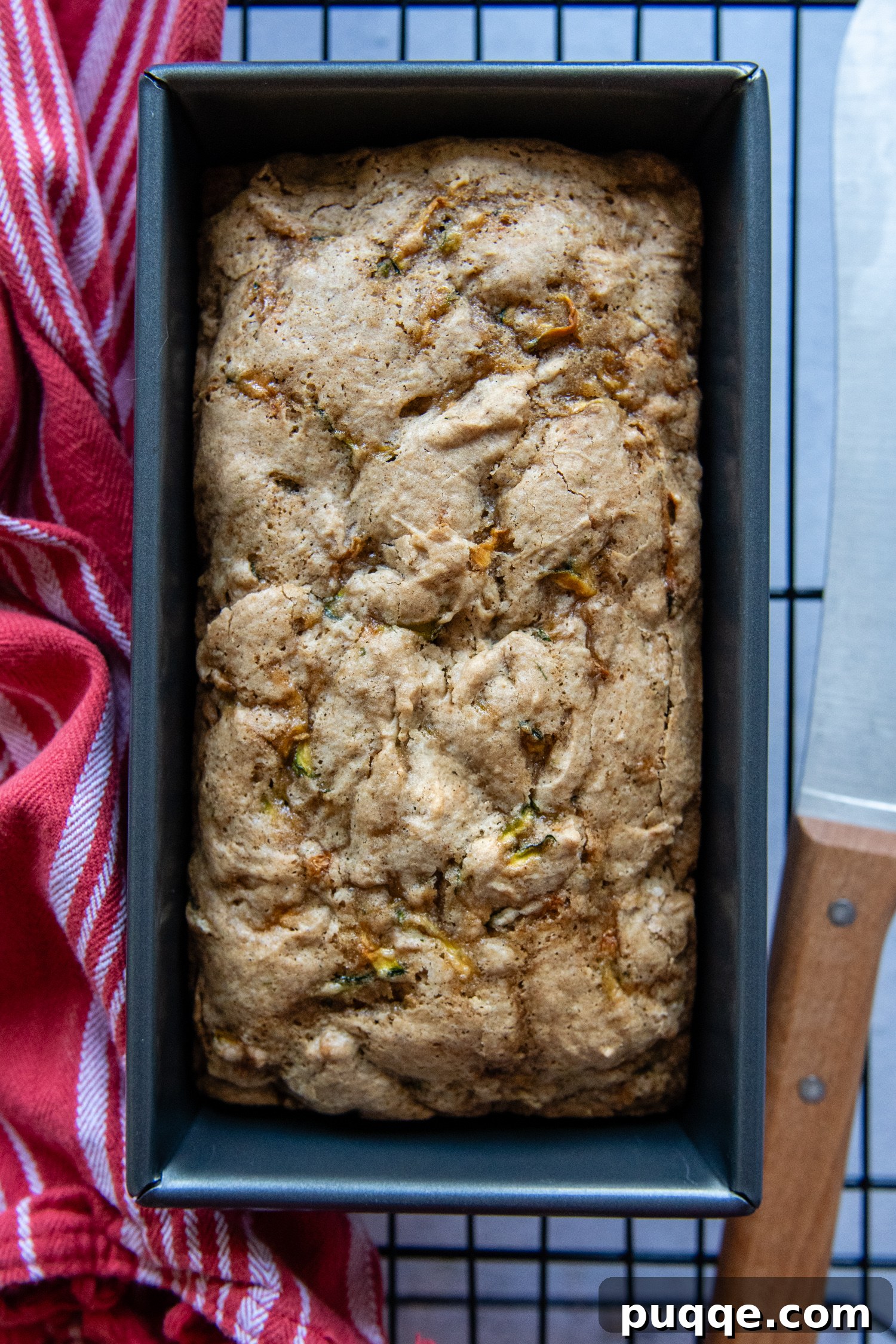Seriously The Best Gluten Free Zucchini Bread Incredibly Moist 7 A freshly baked gluten-free zucchini bread loaf cooling in its pan on a wire rack.