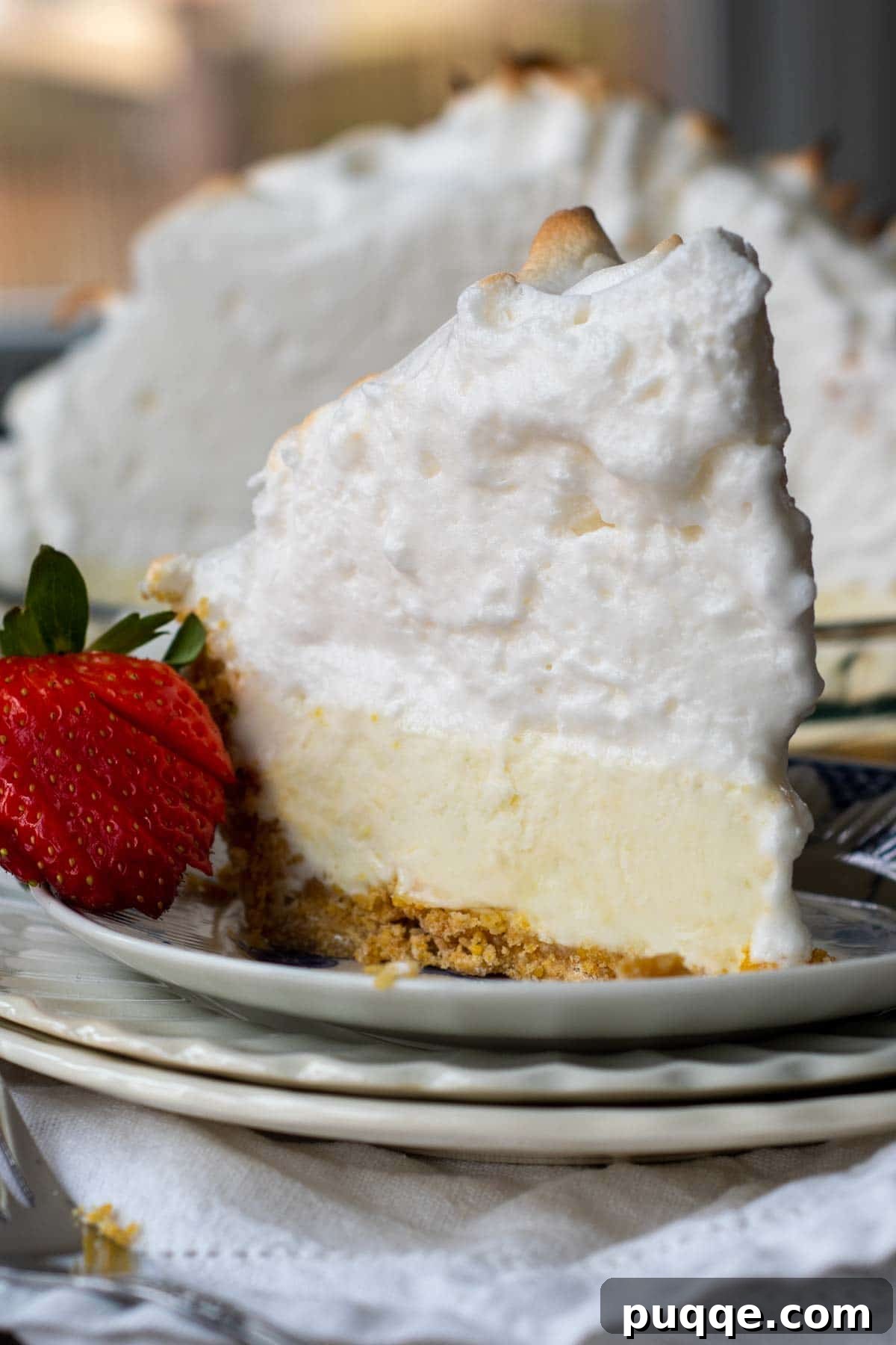 Zesty Frozen Lemon Bliss 5 A perfectly portioned slice of creamy frozen lemon pie presented on a plate, topped with golden toasted meringue, ready to be enjoyed.
