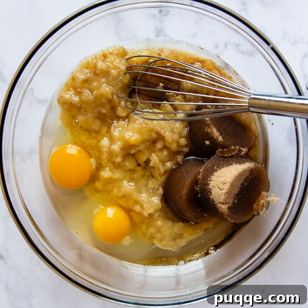 all the liquid ingredients with bananas being whisked together.