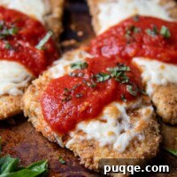 Oven-Crisp Gluten-Free Chicken Parmesan 8 a close up of parmesan chicken on a baking sheet with sauce and cheese on top