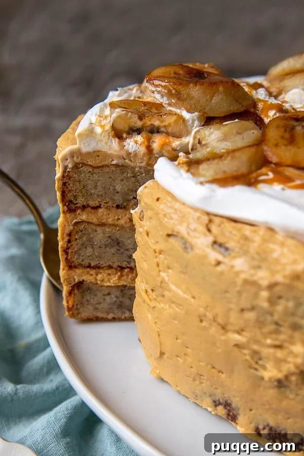 Decadent Banoffee Cake 9 a slice of layer cake being pulled out, showing the neat layers of banana cake and dulce de leche frosting, with pan-fried bananas on top.