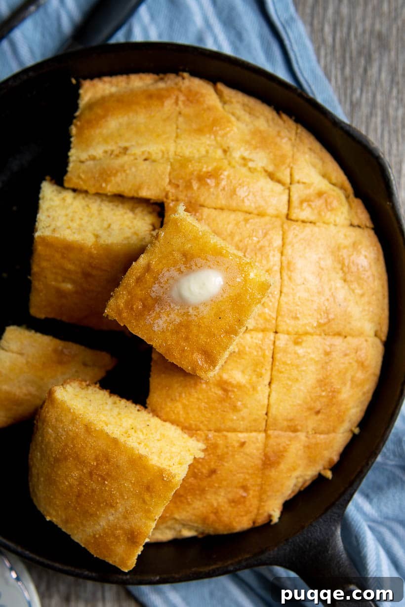 Supremely Fluffy Moist Gluten-Free Cornbread 2 overhead shot of iron skillet with cut cornbread and piece of melting butter on top