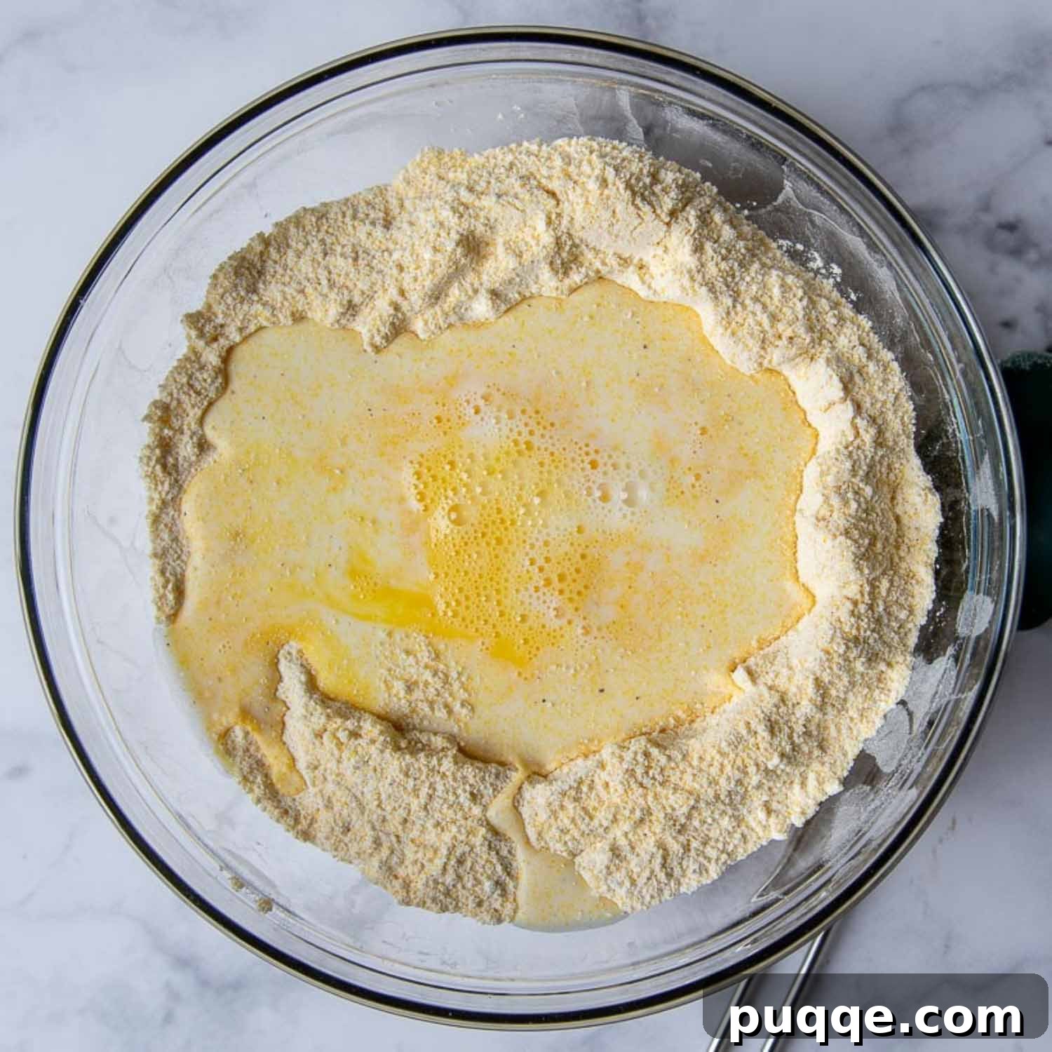 Supremely Fluffy Moist Gluten-Free Cornbread 4 the liquid ingredients being stirred into the dry corn muffin mixture.