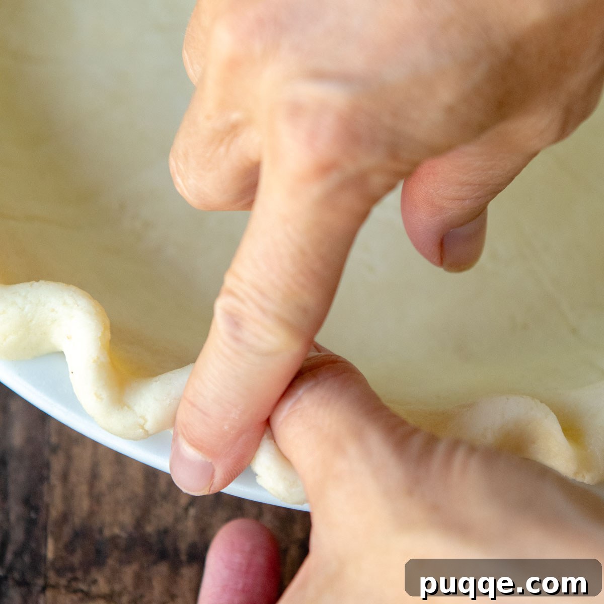 fingers crimping the edges in a decorative flute.