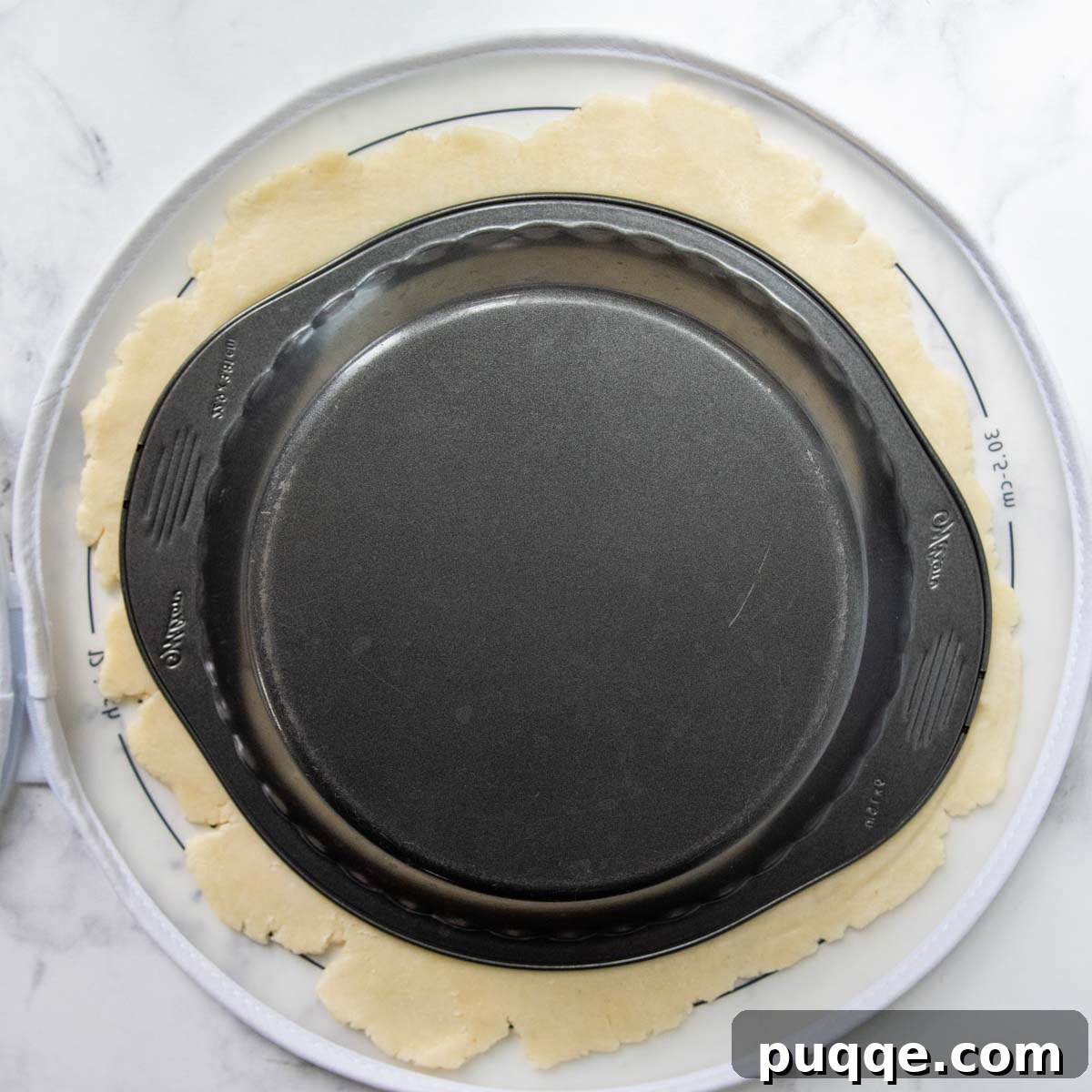a metal pie pan flipped over on the pie dough.