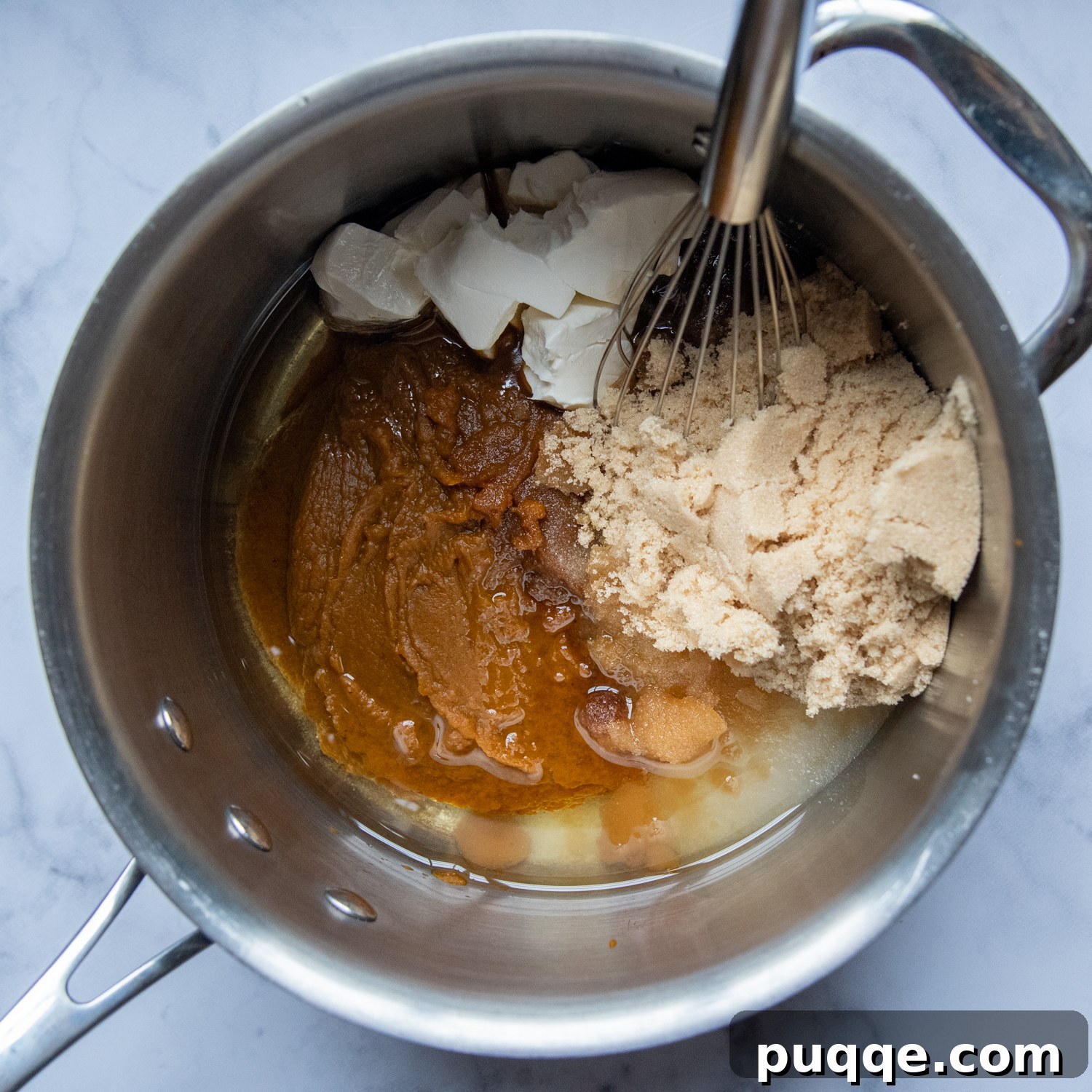 Legendary Fluffy Gluten-Free Pumpkin Bread 4 Brown sugar and softened cream cheese are being vigorously whisked into the warm, cooked pumpkin puree in a large saucepan, creating a smooth, spiced base for the bread batter.
