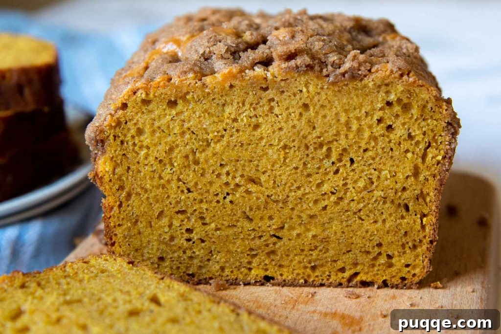 Legendary Fluffy Gluten-Free Pumpkin Bread 6 A perfectly baked gluten-free pumpkin bread loaf, sliced open to reveal its tender, moist, and fluffy interior, showcasing the even distribution of pumpkin and spices.