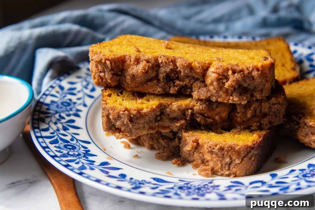 Legendary Fluffy Gluten-Free Pumpkin Bread 7 A close-up view of the golden-brown streusel topping on stacked slices of gluten-free pumpkin bread, highlighting the crumbly texture and sweet spice.