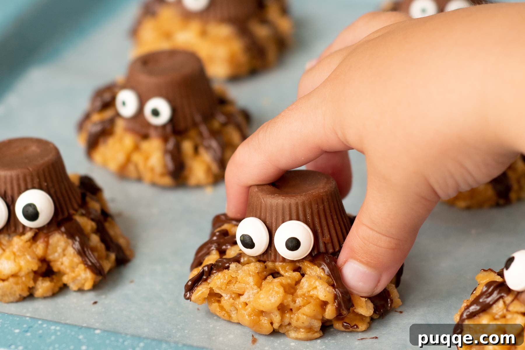 Ghoulishly Easy No-Bake Spider Treats 9 A child's hand eagerly reaching for a finished no-bake spider cookie, highlighting its appeal to kids.