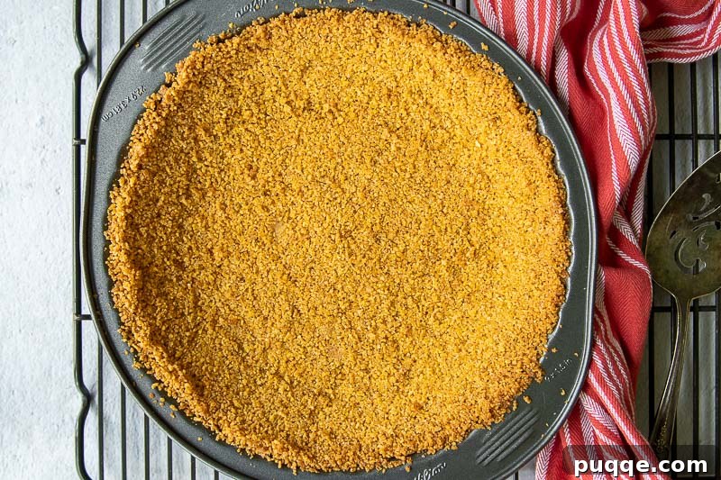 Effortless 5-Minute Gluten-Free Chex Pie Crust 5 Landscape view of a freshly baked Chex cereal pie crust cooling on a wire rack with a rustic red towel nearby, emphasizing homemade comfort.