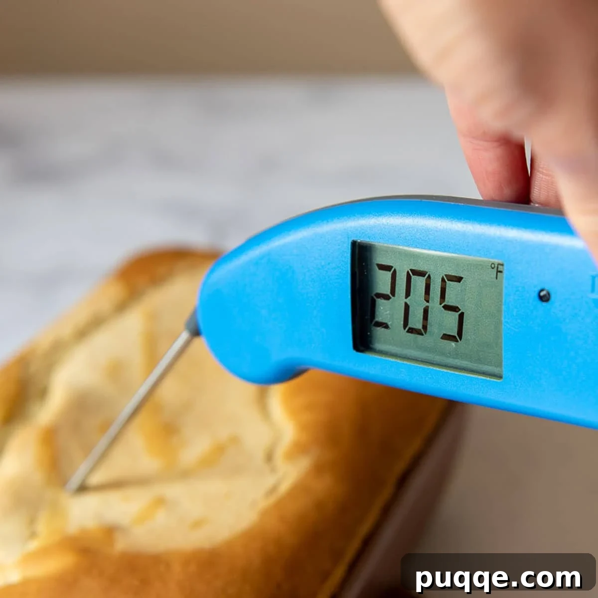a thermometer going into a freshly baked loaf of gluten free bread