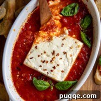 overhead shot of baked feta in a small dish with marinara