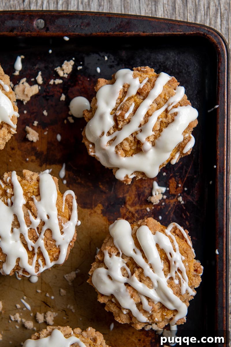 Pillowy Gluten-Free Pumpkin Muffins with a Tangy Cream Cheese Glaze 5 An inviting overhead shot of delicious gluten-free pumpkin muffins generously drizzled with a smooth cream cheese glaze.