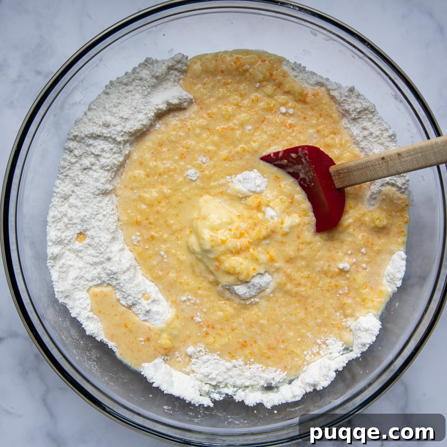Luscious Gluten-Free Cranberry Buttermilk Loaf 5 The dry ingredients, including gluten-free flour, sugar, salt, baking powder, and baking soda, are being stirred into the wet mixture in a large mixing bowl, creating a smooth batter.