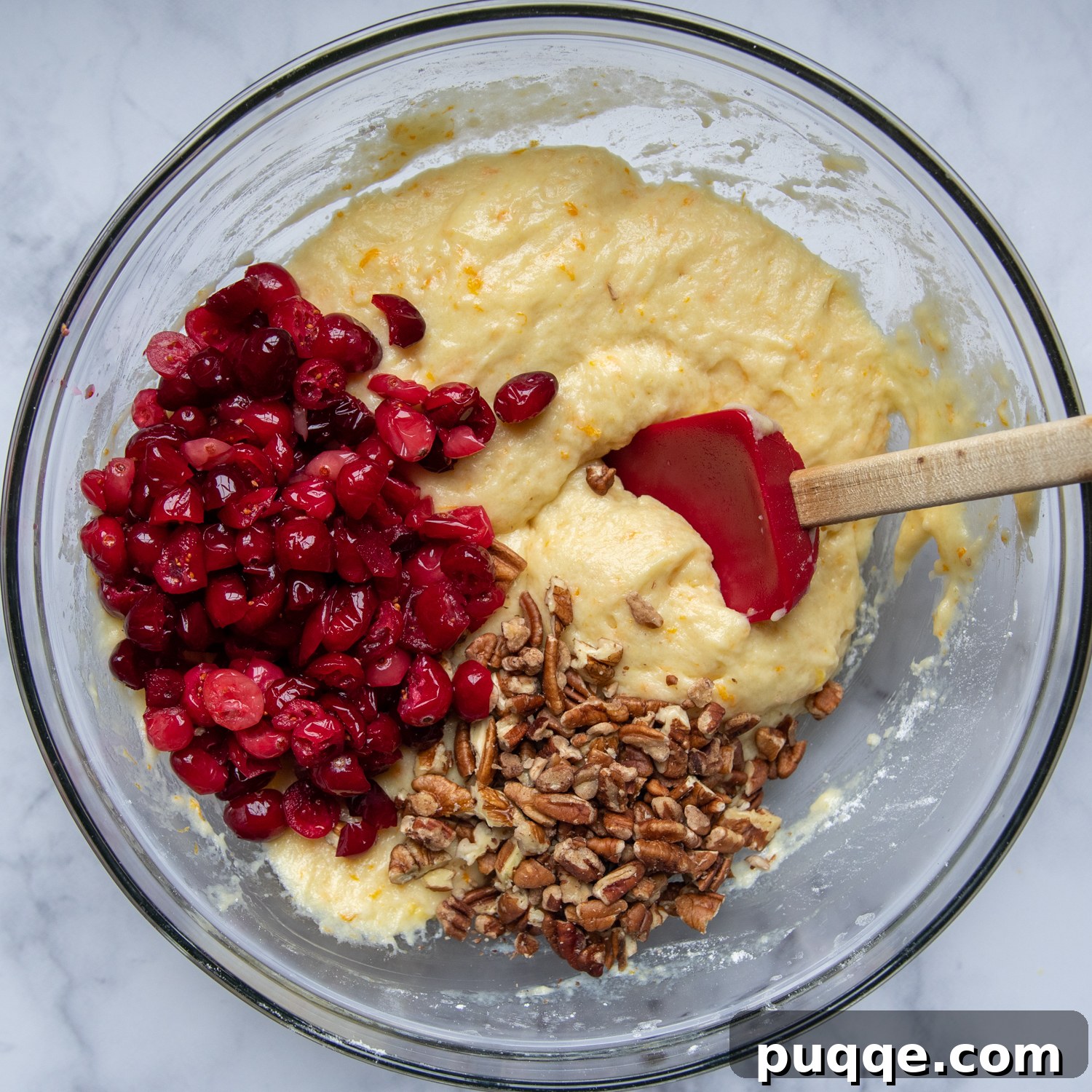 Luscious Gluten-Free Cranberry Buttermilk Loaf 6 Freshly chopped cranberries and walnuts are being gently folded into the cranberry bread batter in a large mixing bowl, preparing it for baking.