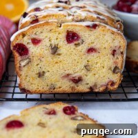 Gluten-Free Cranberry Bread sliced and facing straight out on a cooling rack, showcasing its moist texture and vibrant cranberries.