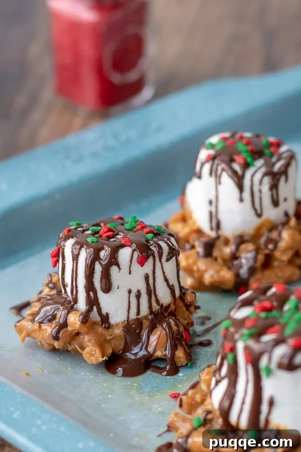 Glistening Caramel Marshmallow Treats on a baking sheet, drizzled with chocolate and ready to enjoy.