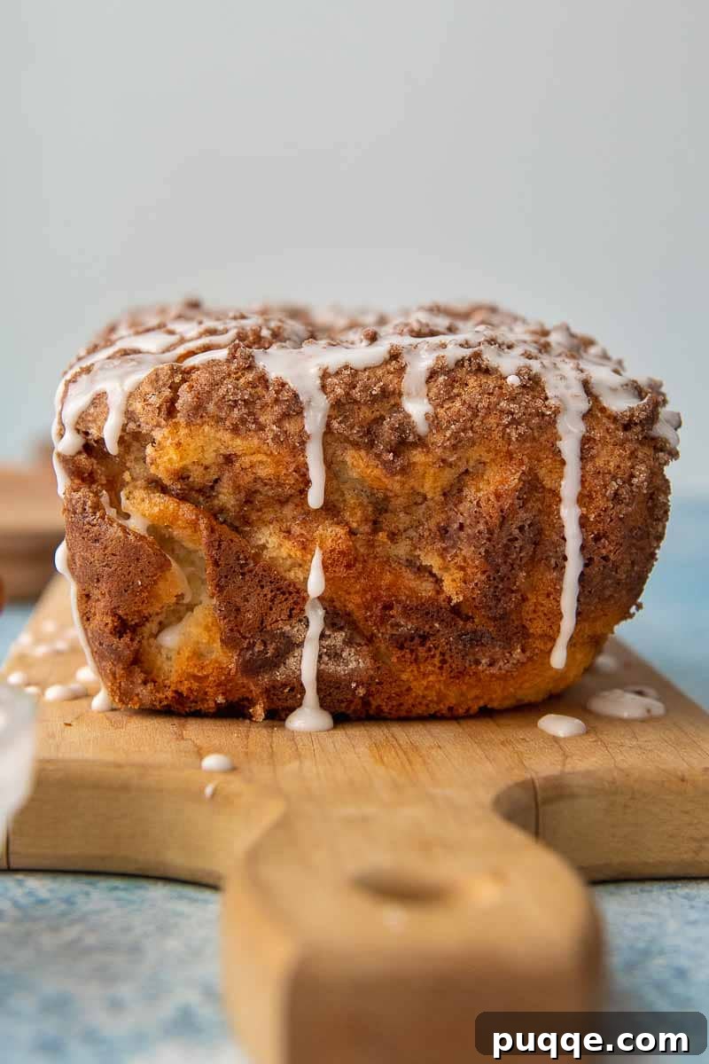 Sweet Cinnamon Gluten-Free Loaf with a Vanilla Drizzle 5 A freshly baked loaf of gluten-free cinnamon bread, generously drizzled with glaze frosting, ready to be sliced and enjoyed, showcasing its inviting texture.