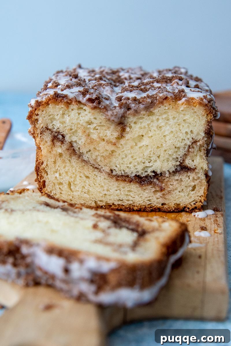 Sweet Cinnamon Gluten-Free Loaf with a Vanilla Drizzle 6 A beautifully sliced loaf of gluten-free cinnamon bread arranged on a wooden cutting board, with individual slices invitingly fanned out, showcasing its moist interior and perfect cinnamon swirl.