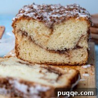 Sweet Cinnamon Gluten-Free Loaf with a Vanilla Drizzle 7 A close-up of a sliced gluten-free cinnamon swirl quick bread on a wooden cutting board, revealing the perfect swirl and moist texture, ready to be served.