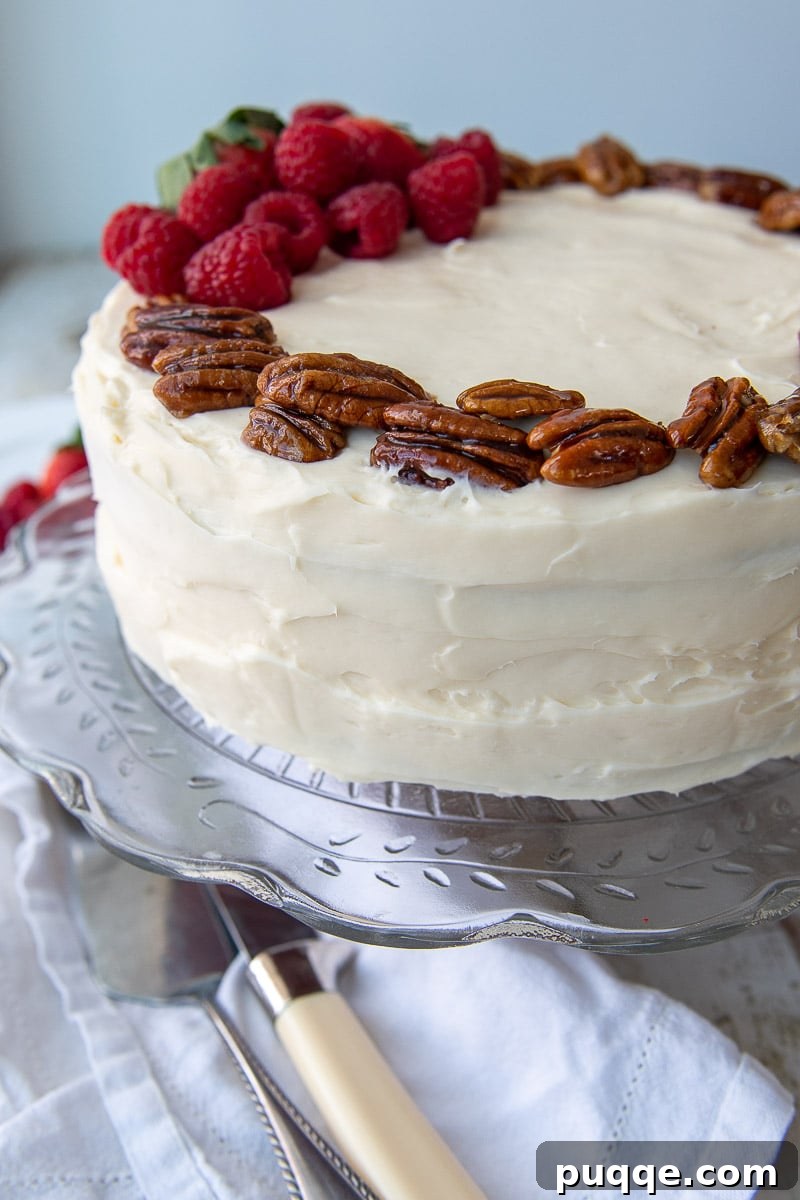 Decadent Gluten Free Red Velvet Pure Moist Perfection 6 A close-up shot of a two-layer gluten-free red velvet cake, generously frosted with fluffy cream cheese frosting and adorned with candied pecans.