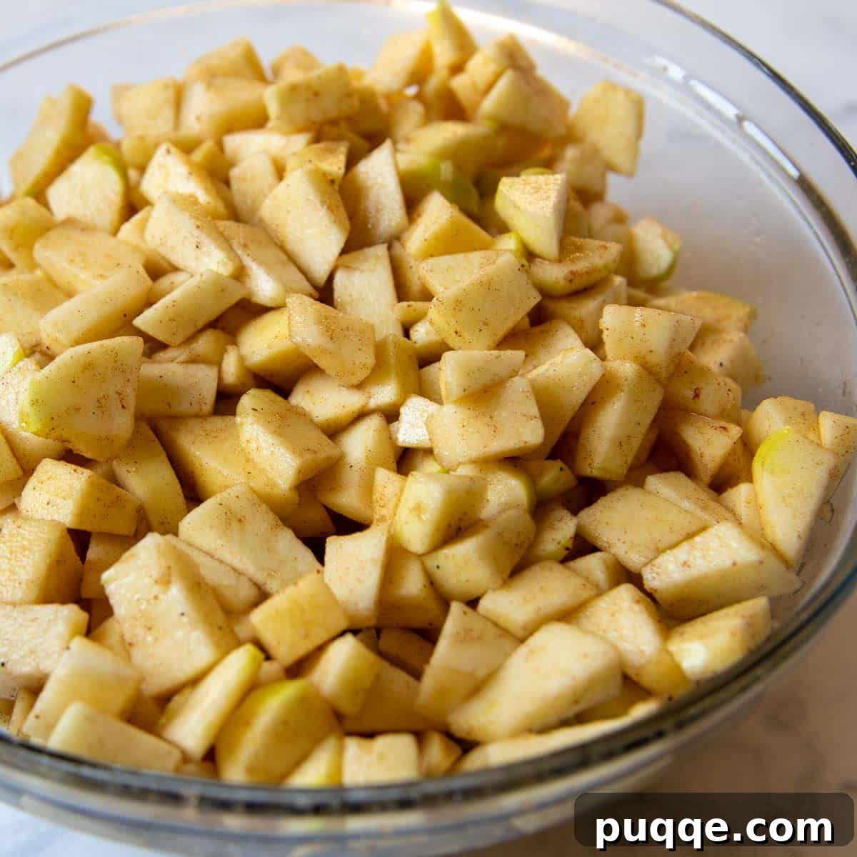Easy Gluten Free Apple Cobbler with Fluffy Biscuit Topping 3 chopped apples in a large glass mixing bowl.