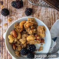 a bowl of homemade granola with milk and berries