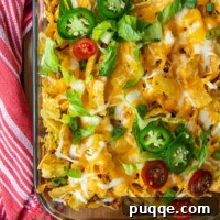 overhead shot of casserole with cheese, tomatoes, and jalapenos on top