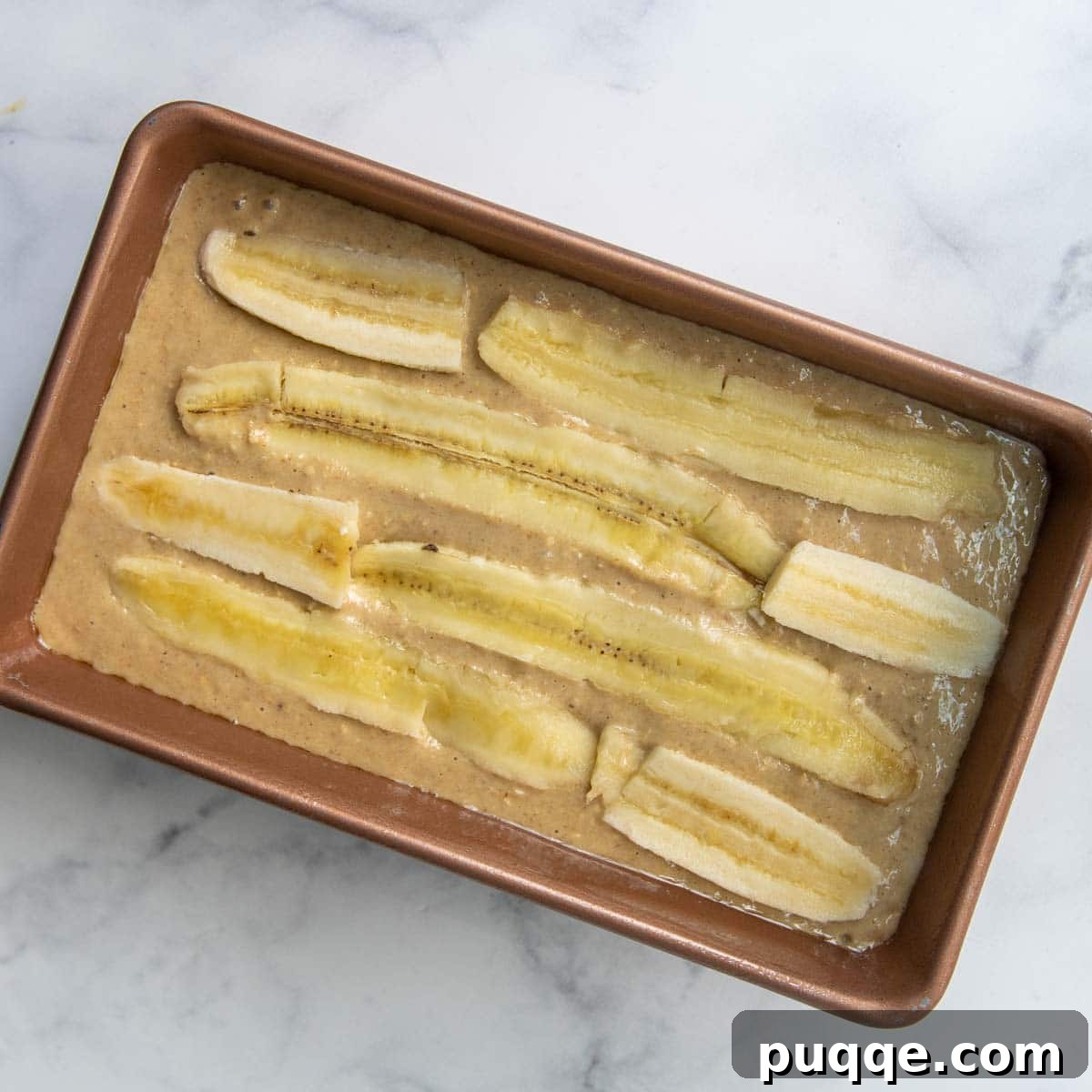 Quick Moist Oat Flour Banana Bread 6 image showing unbaked bread with sliced bananas on top