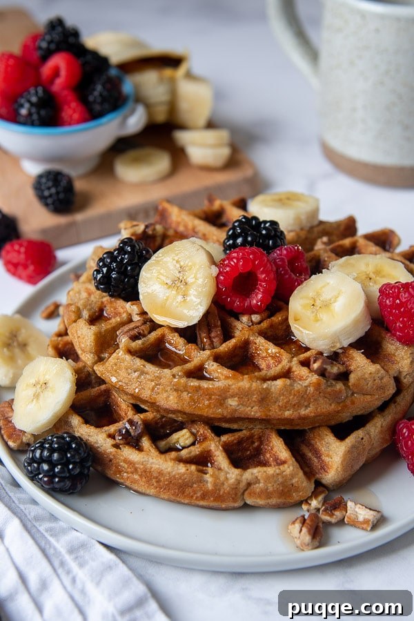 Wallet-Friendly Gluten-Free Meals: 40+ Easy Ideas 38 A vibrant shot of gluten-free waffles on a plate, generously topped with fresh berries, nuts, and banana slices.