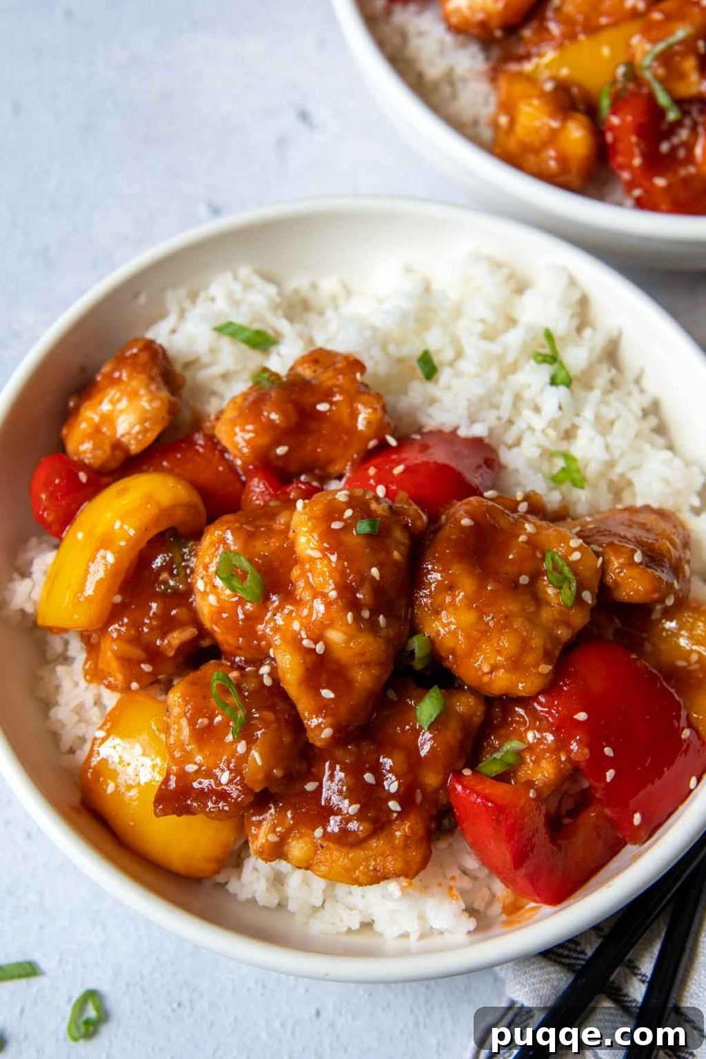 Crispy Baked Gluten-Free Sweet and Sour Chicken 6 Two bowls of crispy gluten-free sweet and sour chicken with chopsticks, ready to eat.