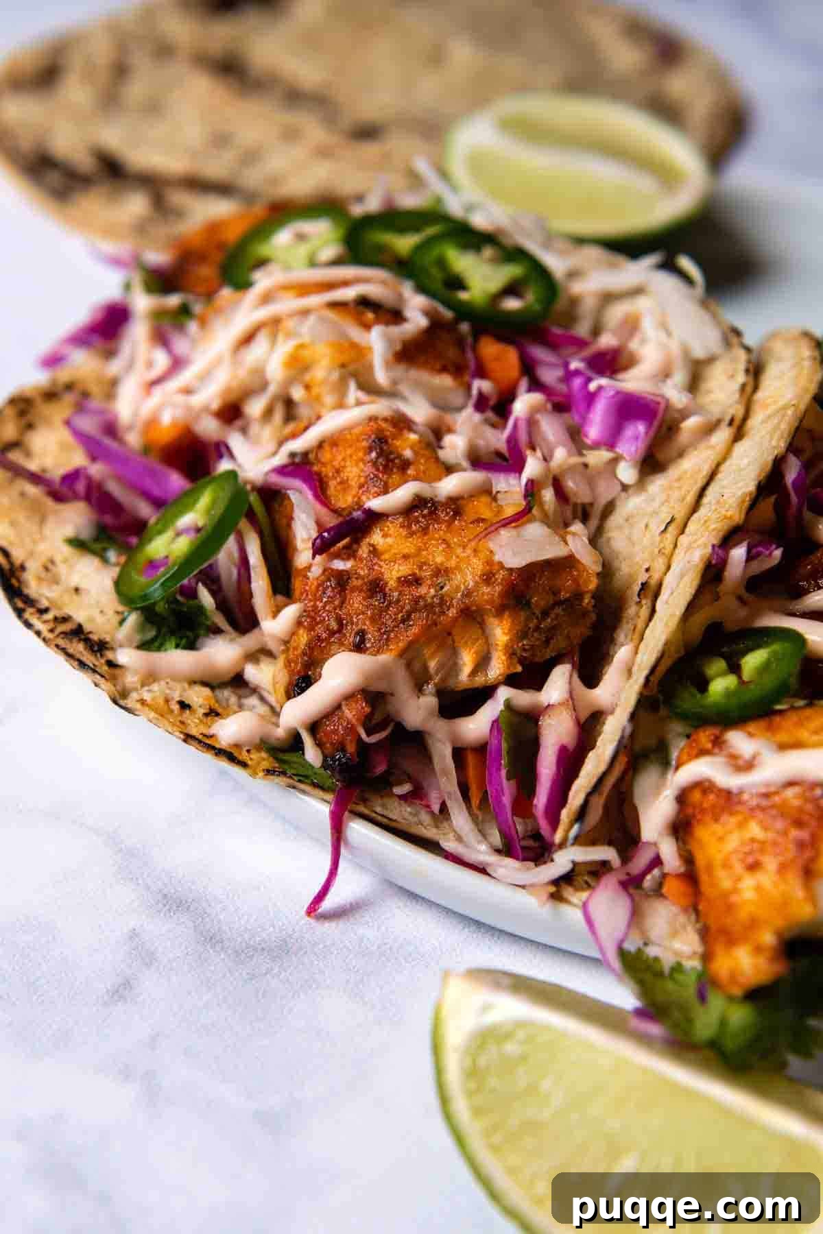Flavorful Gluten Free Blackened Fish Tacos Ready in 30 8 Close-up shot of a single perfectly assembled fish taco on a white marble countertop.