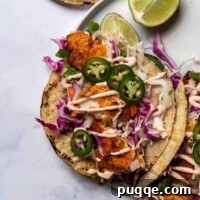 Flavorful Gluten Free Blackened Fish Tacos Ready in 30 9 overhead shot of blackened fish tacos on a white plate with cut limes around