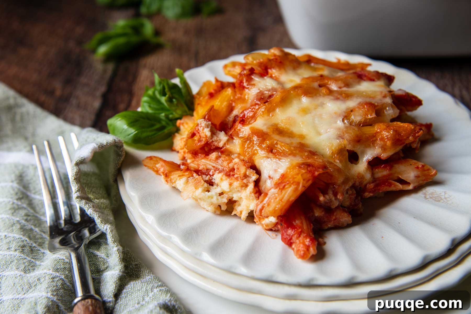 A delectable serving of meatless baked ziti on a white plate, showcasing its creamy layers and golden-brown cheese topping.