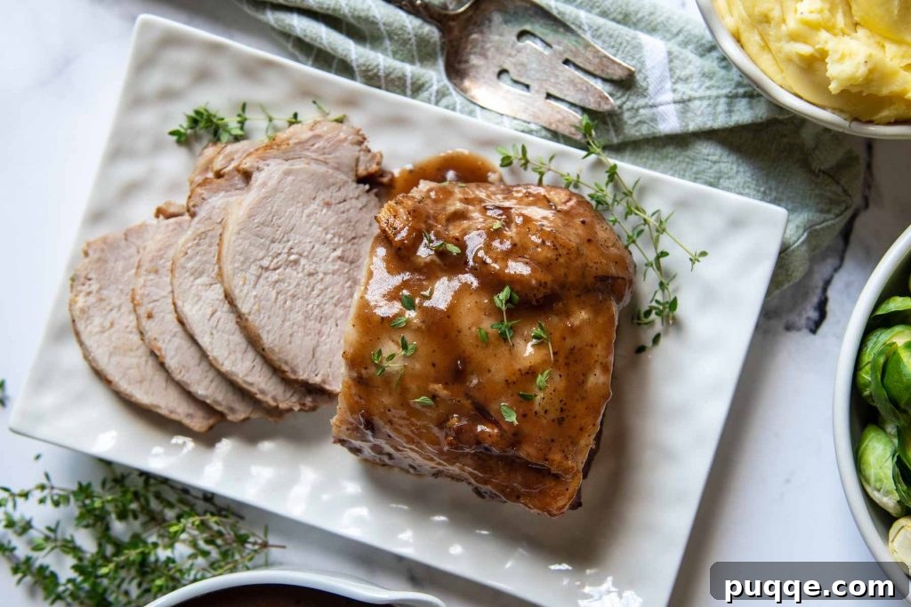 Fall-Apart Tender Instant Pot Pork 5 An inviting overhead shot of a golden-brown pork roast on a white platter, with some slices already carved, showcasing its tender texture.