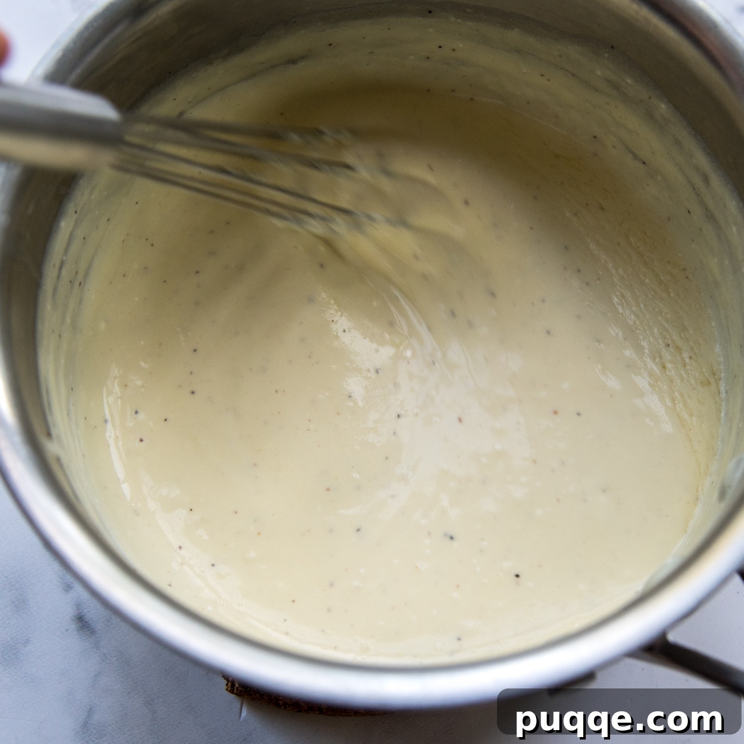 Quick and Creamy Gluten-Free Alfredo in 10 Minutes 4 The smooth, creamy Alfredo sauce, perfectly whisked and simmering in a saucepan, ready to be tossed with pasta.
