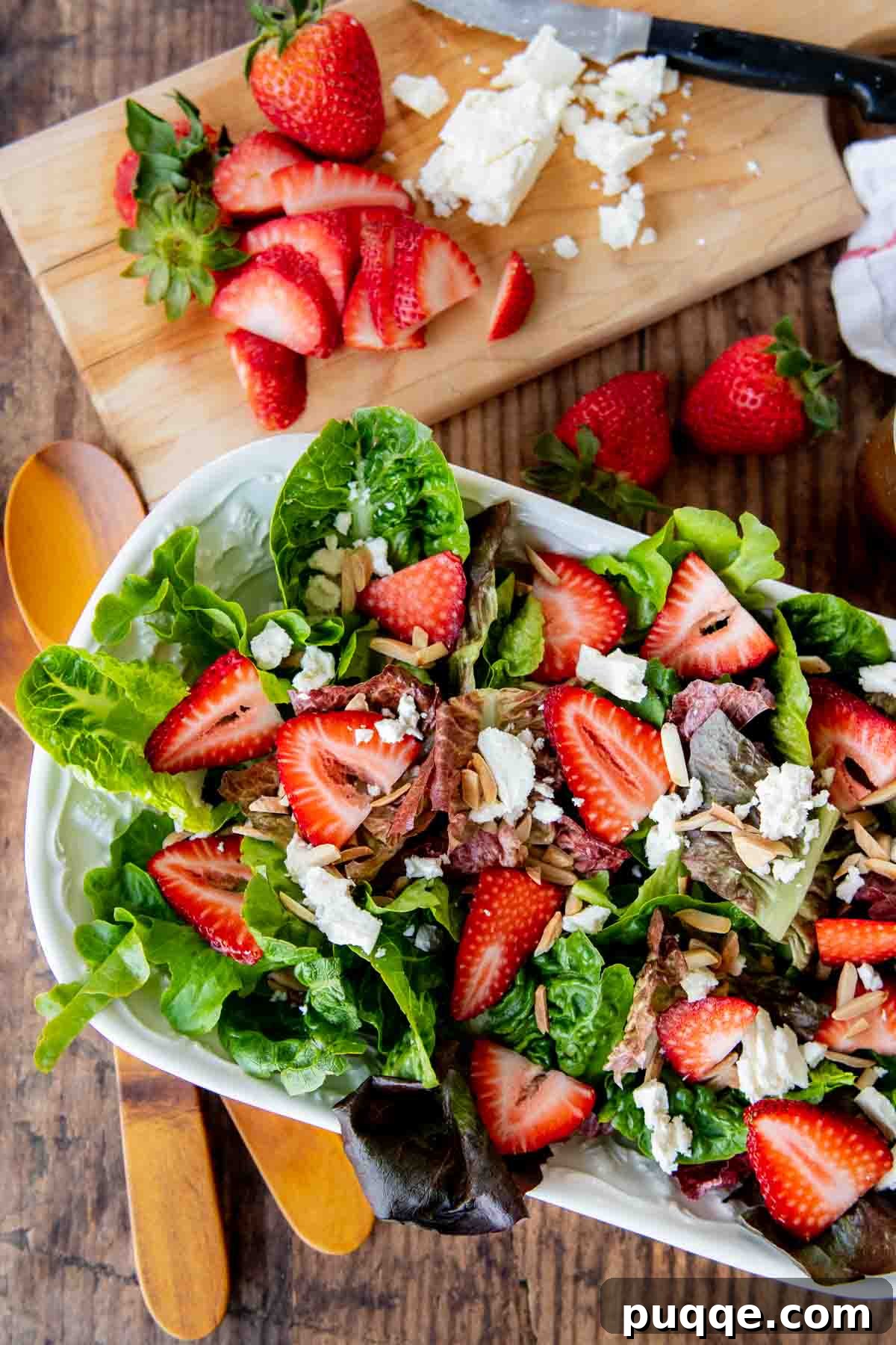 An overhead shot of a vibrant strawberry green salad, generously topped with crumbled feta cheese, inviting a burst of sweet and tangy flavors.