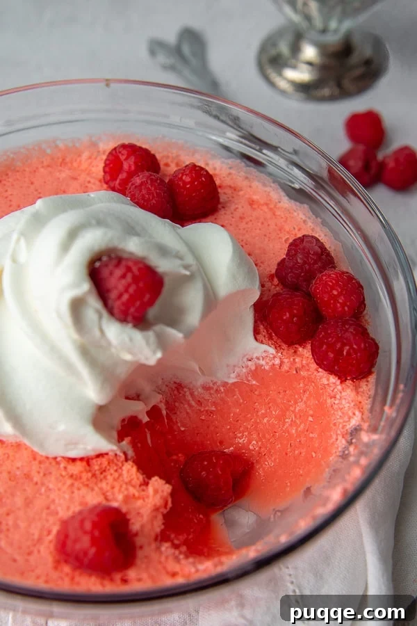 A scoop of vibrant Jello salad delicately taken out of a serving bowl, revealing its creamy texture and promising a refreshing, easy dessert or side dish.